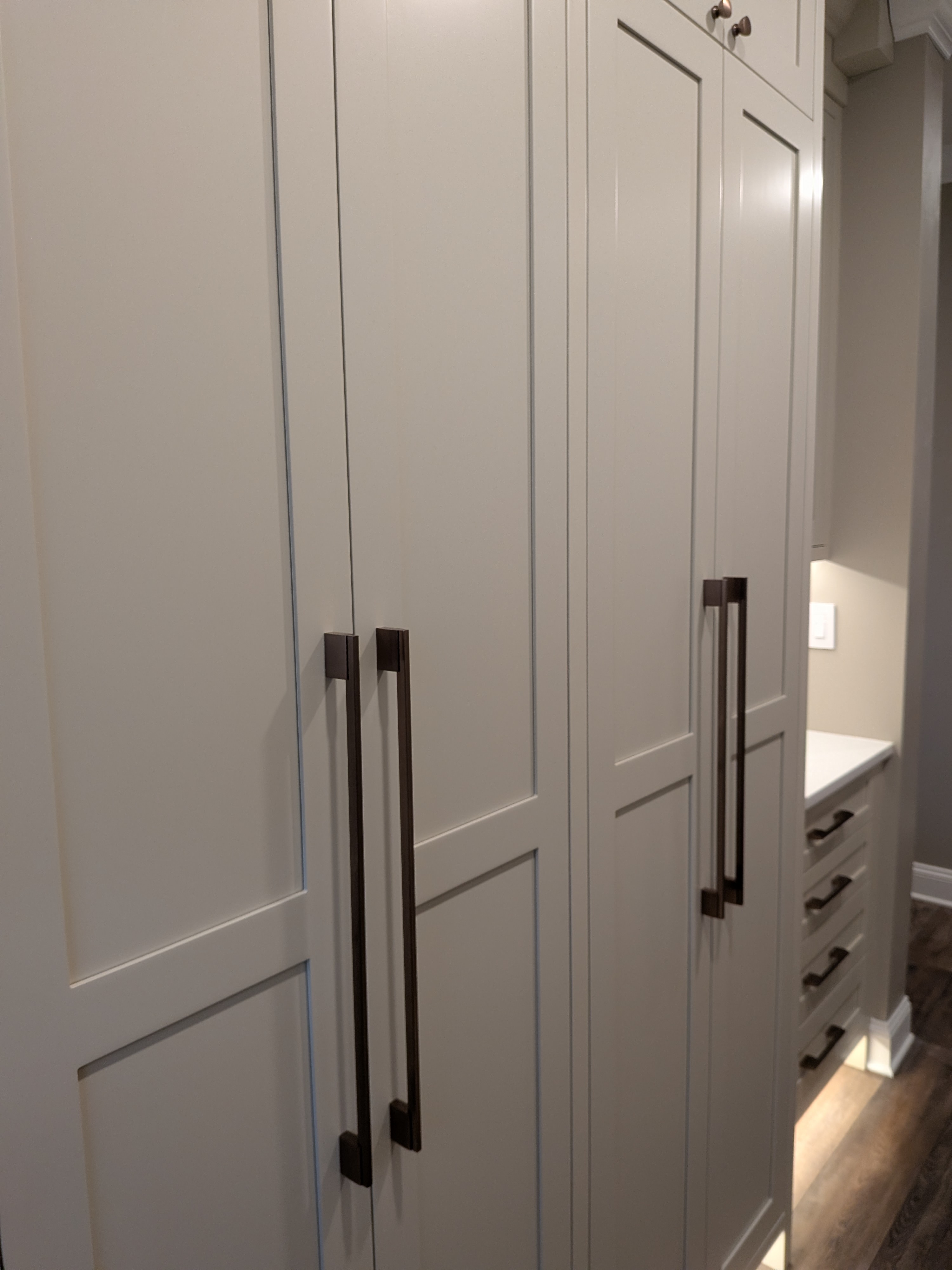 Full-height mudroom cabinets with shaker doors and bronze pulls
